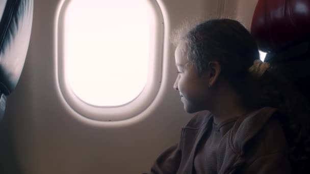 Charmig Flicka Sitter Vid Fönstret Planet Barnet Tittar Genom Fönstret — Stockvideo