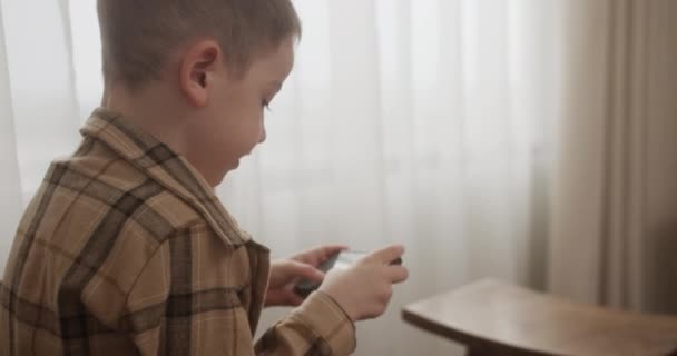 Gyönyörű Gyermek Fiú Éves Játszik Mobil Játék Okostelefon Otthon Imádnivaló — Stock videók