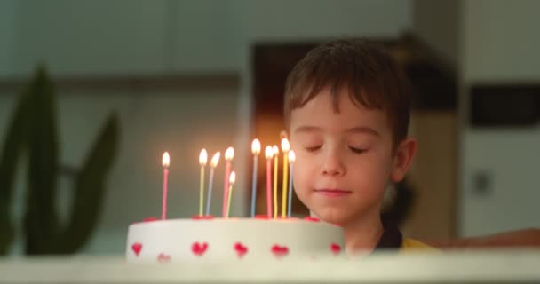 快乐的小孩的画像 漂亮的小男孩闭着眼睛在生日蛋糕上许愿 小孩在家里庆祝生日 — 图库视频影像