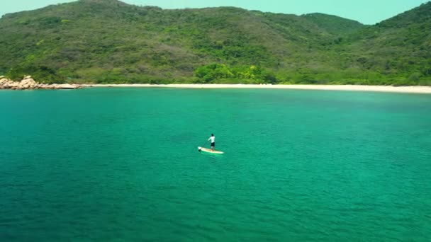 暑假期间从事水上运动的人 积极旅游和旅行的概念 空中看到一个人拿着桨在山上的海面上吃水 — 图库视频影像