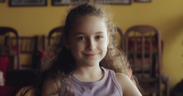 Porträtt Rolig Liten Flicka Leende Barn Tittar Kameran Sitter Soffan — Stockvideo