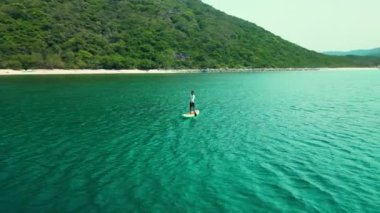 Yaz tatilinde su sporu yapan bir adam. Aktif turizm ve seyahat kavramı. Kürekli bir adamın havadan görünüşü dağlarda, denizde yemek masasında..
