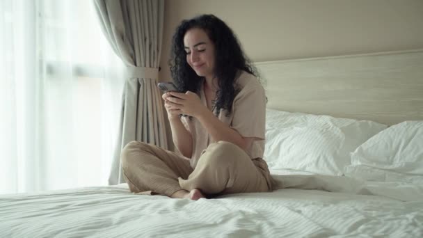 Yatak Odasında Otururken Akıllı Telefon Kullanan Bir Kadın Evde Cep — Stok video