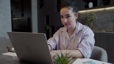 Hintli kadın ofisinde ya da mutfağında oturuyor dizüstü bilgisayarını kullanıyor e-postayı kontrol ediyor ve harika haberler okuyor. Satış fiyatları iyi, kariyer promosyonu maaş artışı, online açık artırma kazananı parasal zafer kavramını kutluyor.