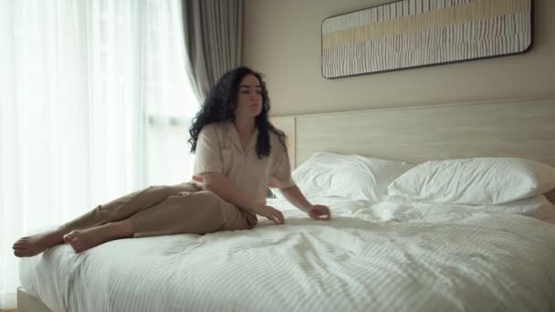 Utmattad Eller Uttråkad Sömnig Kvinna Sitter Sängen Tittar Genom Fönstret — Stockvideo