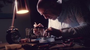 Bir mikro devreyi tamir etmek, lehimleme demiri dumanı. Telsiz bileşenlerini sökmek. Değerli metal, altın rengi lehimler. Transistörler, Elektronik Tahtada lehimli Radyo Elektronik Parçalar.