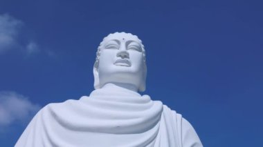 Uçsuz bucaksız mavi gökyüzü ve Vietnam 'ın Büyük Buda' sı. Uçsuz bucaksız mavi gökyüzünde büyük Buda beyaz heykeli. Beyaz Buda Vietnam, Nha Trang Vietnam 'ın simgelerinden biridir. 4K.