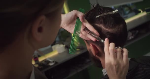 Berber Dükkanında Oturan Şık Bir Adam Kuaför Kadın Saçını Kesiyor — Stok video