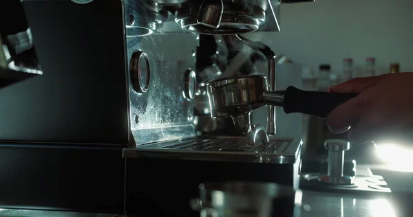Taze öğütülmüş kahve akar. Sabahleyin kavrulmuş sade kahve iç. Kahve makinesinde bir fincan koyu kahve hazırla, arka ışık buharı ve fincanı aydınlatır. 4K.