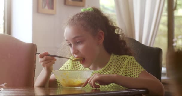 Ładna Dziewczynka Siedzącą Przy Stole Kuchni Jedzącą Zupę Dyniową Śniadanie — Wideo stockowe