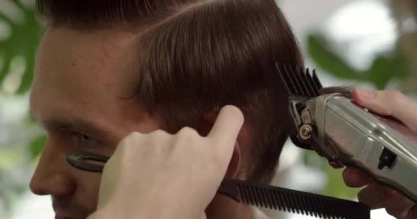 美容師は ヘアコームとヘアマシンとヘアスタイルを作ります — ストック動画