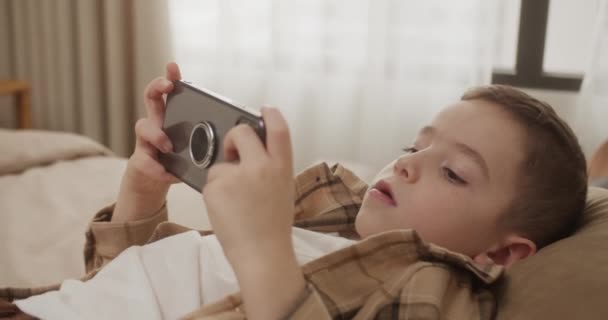 Vackra Barn Pojke Spelar Mobilspel Smartphone Hemma Söt Pojke Som — Stockvideo