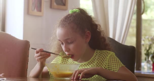Ładna Dziewczynka Siedzącą Przy Stole Kuchni Jedzącą Zupę Dyniową Śniadanie — Wideo stockowe