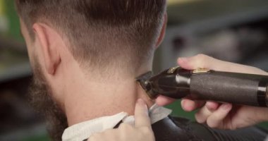 Kuaför saç tarağı ve saç makinesiyle saç stili yapıyor. 4K.