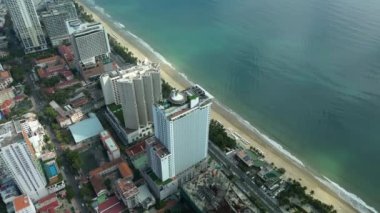 Nha Trang, Vietnam - 05 Şubat 2023: Nha Trang 'da büyük bir yüzme havuzu olan yüksek binalı gökdelenlerin insansız hava aracı görüntüsü. Nha Trang 'ın kıyı şeridi. 4K.