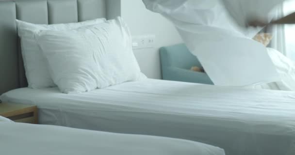 従業員 ホテルの2人のメイドは 専門的にクライアントルームでベッドを作ります 5つ星ホテルのコンセプトと質の高いルームサービス 女性は部屋の寝具を変える — ストック動画