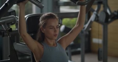 Sportif genç bir kadın spor salonunda kaslarını çalıştırıyor. Spor salonunda kadın eli, vücut geliştiren dambılları alıyor. Spor kulübünde ağırlık kaldıran bir kadın. Spor salonunda spor eğitimi alan fitness kızı..