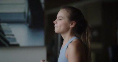 Spor salonunda koşu bandında koşan fitness kadını. Sporcu spor salonunda çalışan bir makine kullanır. Güzel kız spor kulübünde kardiyo antrenmanı yapıyor..