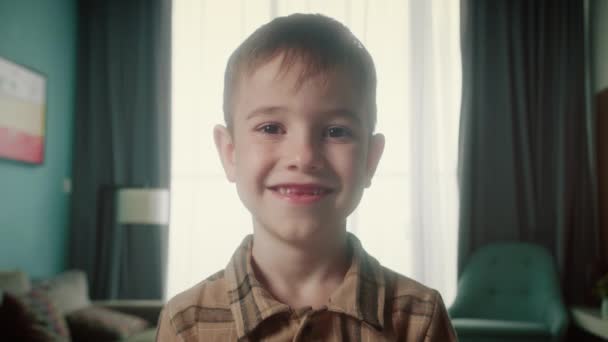 Portret Zabawny Chłopiec Uśmiechnięte Dziecko Patrząc Obiektyw Siedzą Kanapie Domu — Wideo stockowe