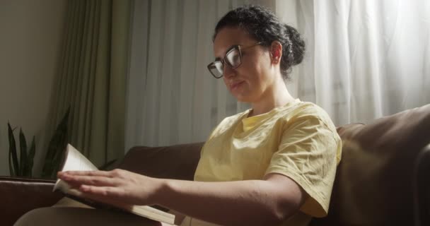 Genç Kadın Rahat Oturma Odasında Kitap Okuyor Sayfayı Çeviriyor Öğreniyor — Stok video