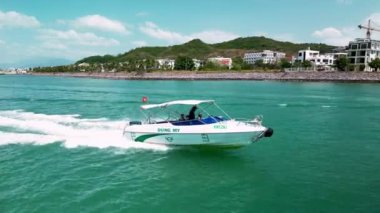 Nha Trang, Vietnam - 10 Şubat 2023: Sürat teknesi turistlerle birlikte Vietnam 'da bir deniz gezisinde. Balıkçı gemileri Vietnam 'da balıkçılığa hazırlanıyor. 4K.