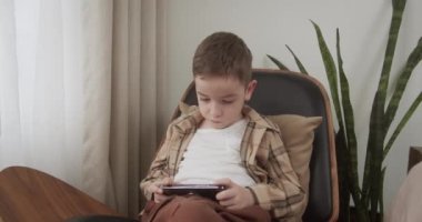 Halı döşemesinde dijital tablet teknolojisi kullanan meraklı anaokulu öğrencisi kız. Evde internette sörf yapan küçük bir çocuk. Çocuklar teknoloji bağımlılığı kavramı