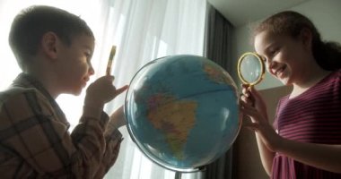 Çocuklar evde otururken gün batımını seyrediyor. Sabahları gün batımında çocuklar, Dünya 'lı şirin çocuklar ve büyüteç, okul çocuğu için teknoloji, dünya' ya bakıyor.