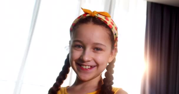 形象滑稽的小女孩微笑着看着镜头 可爱的小女孩有着漂亮的脸蛋 幸福童年的概念 — 图库视频影像