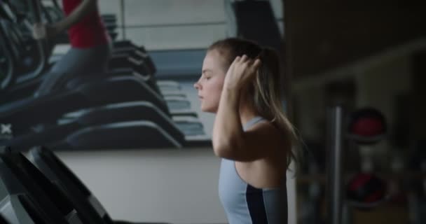 ジムでトレッドミルを走っているフィットネス女性 アスリートはフィットネスセンターでランニングマシンを使用しています 可愛いです女の子行う心臓トレーニングでAスポーツクラブ — ストック動画