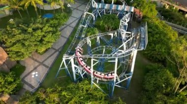 Kırmızı ve mavi roller coaster 'ın en güzel pov çekimi. Lunaparktaki lunaparkta hız treni. Park eğlencelerinde neşeli eğlenceler olur. Üst görüntü kırmızı hız trenini büküyor. 4K.