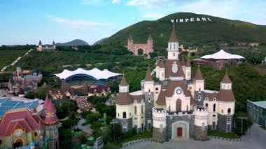 Şatoları, Amerikan trenleri ve dönme dolabı olan turizm adası Vininci. Yeşil dağlara karşı birçok büyük şatonun bulunduğu bir lunapark içine bakın. Vietnam, Vininci 817 2023