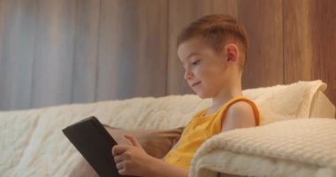 Çocuk 4-5 yıldır oturma odasında tablet kullanmaktan korkuyor, küçük çocuk kucağında bilgisayar sörfü ev konseptinde güvenli olmayan internet, sosyal medyada ebeveyn güvenliği çocuğu