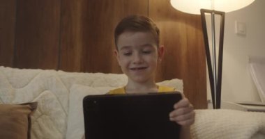 Çocuk 4-5 yıldır oturma odasında tablet kullanmaktan korkuyor, küçük çocuk kucağında bilgisayar sörfü ev konseptinde güvenli olmayan internet, sosyal medyada ebeveyn güvenliği çocuğu
