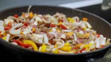 Kadın kızarmış et yahnisine karabiber serpiyor. Sebze ve et. Kızartma tavasında sebze güveci hazırla. Salata için taze sebzeler. Yarı bitmiş yemek. 4K
