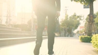 Deri ayakkabılı ve takım elbiseli kendine güvenen adam ofis binasına gidiyor. Şehir merkezinde resmi takım elbiseli bir işçi el çantası taşıyor..