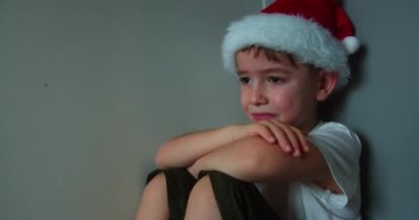 Noel Baba 'nın Noel Baba' sında, yanaklarından büyük gözyaşları süzülen sevimli çocuk, köşede oturan çocuk, çığlık atan bir yüzle gözyaşları akıyor. Çocuk Üzgün .