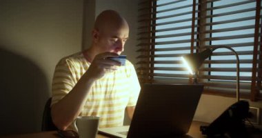 Kredi kartı tutan mutlu bir adam bankaya online ödeme yapıyor. İnternet mağazasında satın almak için laptop teknolojisi kullanan insan tüketicisi. Etrade web sitesi ödemeleri konsepti. Manzarayı kapat. 4K