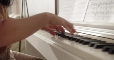 Erkek oynarken piyano eller. Piyanoda bilezik ile eller. Kadın parmakları tuşları üzerinde dokunur. Yakın çekim.