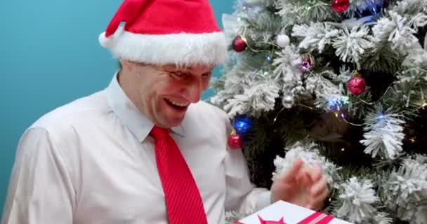 Gelukkig Vader Een Kerstmuts Kerstman Ontvangt Een Geschenk Kijkt Doos — Stockvideo
