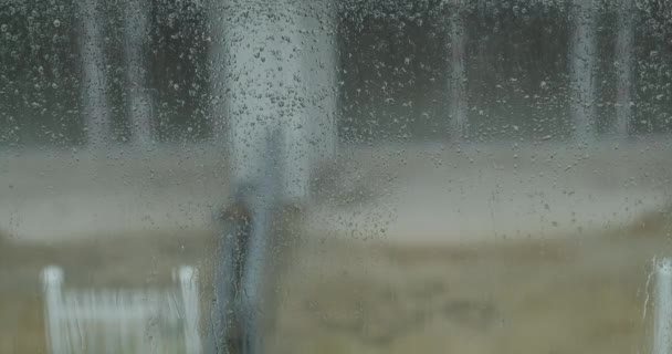 Bei Einem Sommerschauer Schlagen Große Regentropfen Gegen Eine Fensterscheibe Wassertropfen — Stockvideo