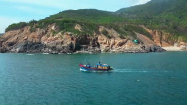Vietnam 'daki balıkçılar Nha Trang, güneşli bir günde güzel bir manzaranın ve harika dağların zemininde yelken açıyorlar. Güneşli bir sabahta, balıkçı teknesi deniz mahsullerini yakalamak için acele eder.