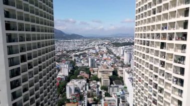 Yüksek binaların insansız hava aracı görüntüleri. Vietnamlıların gökdelenleri binalara yaklaşıyor. Khanh Hoa, Nha Trang, Vietnam. Güneşli zaman, arkadaki mavi ufuk. 4k.