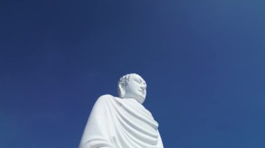 Vietnam 'ın Büyük Buddha' sı üzerindeki hava manzarası. Sinek kamerası, yüksek pagoda ve uçsuz bucaksız mavi gökyüzüne karşı büyük beyaz Buda heykeline iniyor. Beyaz Buda Vietnam 'ı Nha Trang Vietnam' ın simgelerinden biridir. 4K