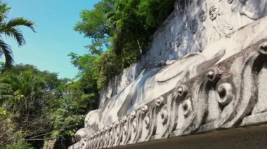 Vietnam 'daki beyaz uzanmış Büyük Buda, Mui Nes' in Vietnam 'daki cazibelerinden biridir. Uçsuz bucaksız mavi gökyüzü ve Vietnam 'ın Büyük Buda' sı. Güneşli bir günde büyük beyaz Buda heykeli. 4K.