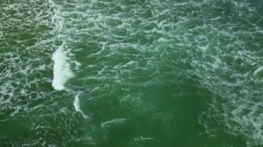 Deniz dalgaları kumlu sahil şeridinde dalgalanırken hiç bitmeyen güzel ve kusursuz görüntülerin drone görüntüsü. Altın plajın havadaki görüntüsü derin mavi okyanus suyu ve köpüklü dalgalarla buluşuyor..