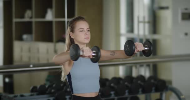 Fitnessz Lány Súlyzózik Egy Sportklubban Egy Erőnléti Gyakorlatokat Végez Súlyzókkal — Stock videók