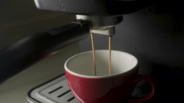 Ev yapımı sıcak Espresso. Filtre tutacağı kullanılıyor. Sabahları kavrulmuş sade kahve içmek. Taze kahve akıyor. Kahve makinesinden fincana kahve dökülüyor. 4K.