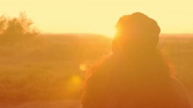 Güneşli bir günde, sonbaharda parkta yürüyen ve gülümseyen çekici esmer bir kadının portresi. Sonbaharda açık havada mutlu ve güzel bir kadının yüzü. Yavaş çekim 4k görüntü