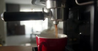 Kahve makinesinin fincanından dökülen kahvenin görüntüsü. Ev yapımı sıcak Espresso. Filtre tutacağı kullanılıyor. Taze kahve akıyor. Sabahları kavrulmuş sade kahve içmek..