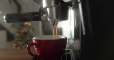 Kahve makinesinin fincanından dökülen kahvenin görüntüsü. Ev yapımı sıcak Espresso. Filtre tutacağı kullanılıyor. Taze kahve akıyor. Sabahları kavrulmuş sade kahve içmek..